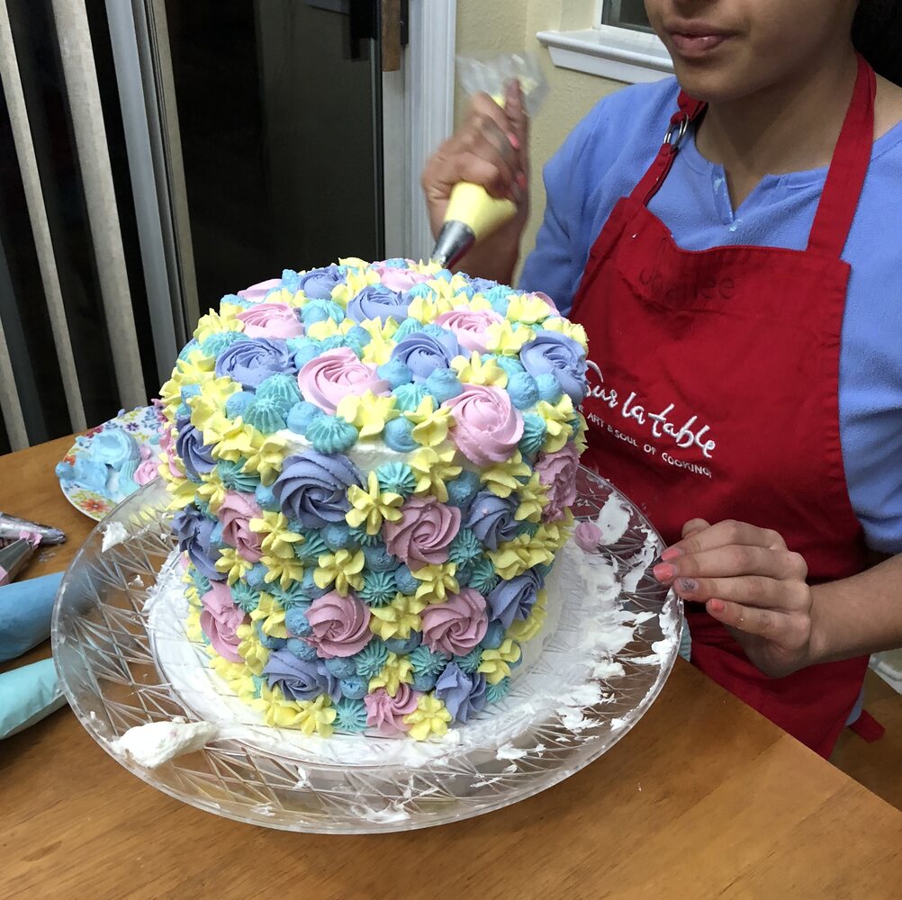 Shailee decorating a floral layer cake
